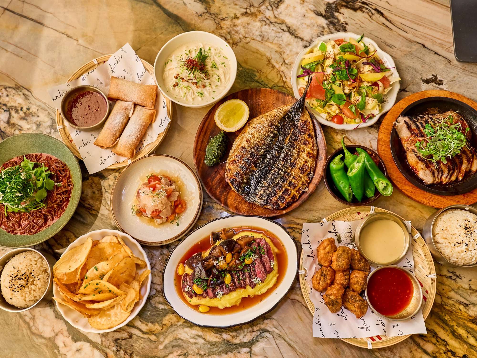 A spread of Danbi dishes on a marble table